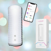 Image of the Lovense Max 2 Penis Masturbator with Bluetooth App in a white, ribbed design, featuring side buttons and paired with a smartphone displaying an app-controlled interface. The product box, labeled "Lovense Max 2" with the Lovense branding, is also visible against a blurred colorful background.